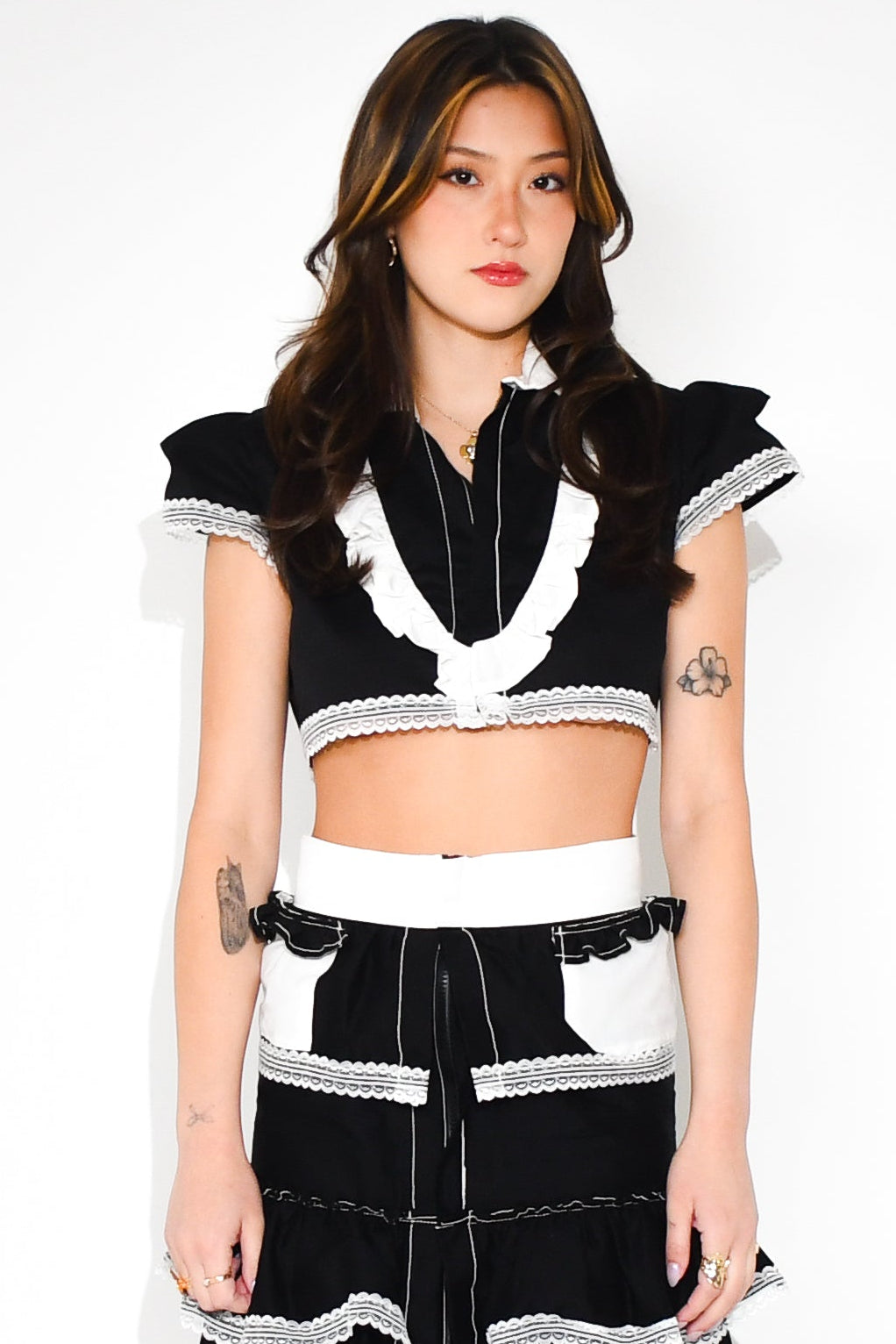 Woman wearing a black and white outfit with a long skirt on a white background
